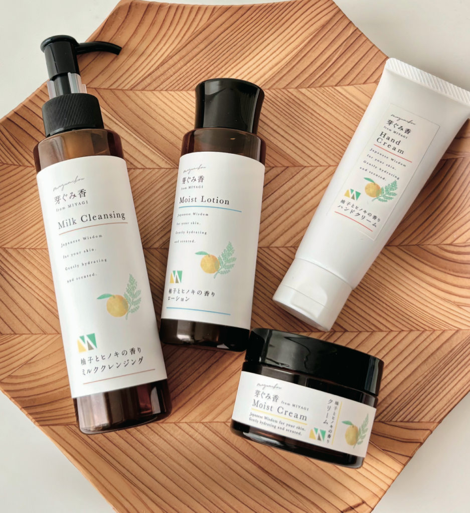 Set of Japanese skincare bottles labeled Milk Cleansing, Moist Lotion, Hand Cream, and Moist Cream on a wooden tray.